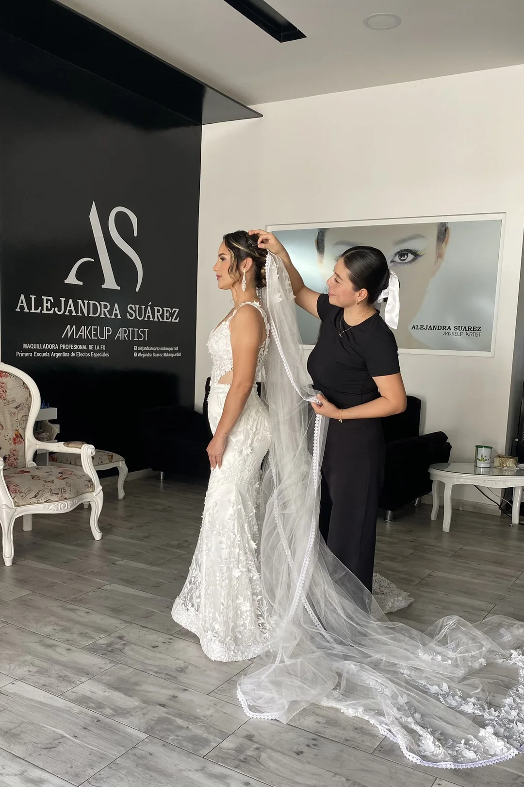 Alejandra ajustando velo de novia frente a la pared con branding oficial AS Makeup Artist
